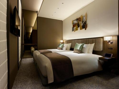 a hotel room with a large bed with green pillows at Hotel The Celestine Ginza in Tokyo