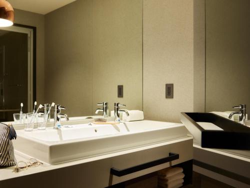 baño con 2 lavabos y espejo grande en Mitsui Garden Hotel Sapporo West en Sapporo