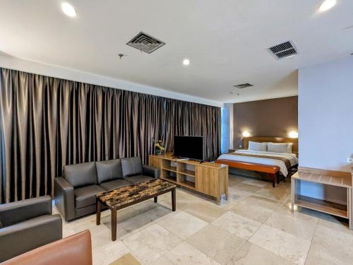 een hotelkamer met een bed en een woonkamer bij Grand Zuri Pematangsiantar in Pematangsiantar