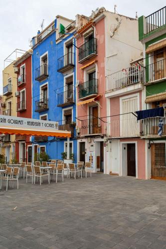 a row of colorful buildings with tables and chairs at Arsenal 31 by Seaward Suites in Villajoyosa