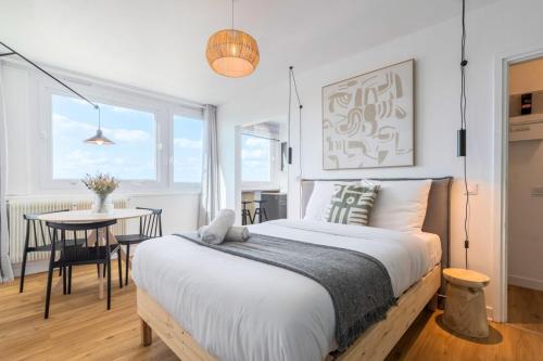 ein Schlafzimmer mit einem großen Bett und einem Tisch in der Unterkunft Lille Hellemmes - Nice studio with parking ! in Lille