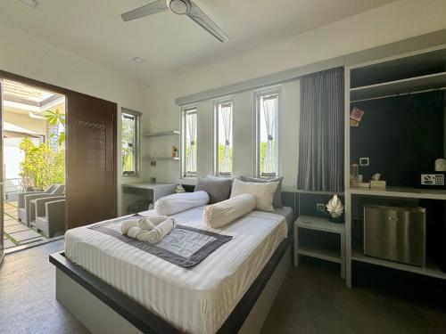 1 dormitorio con 1 cama grande con sábanas blancas en Villa Rumah Putih Abu Abu en Senggigi 