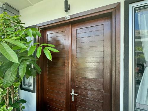a wooden door in a house at Villa Rumah Putih Abu Abu in Senggigi 