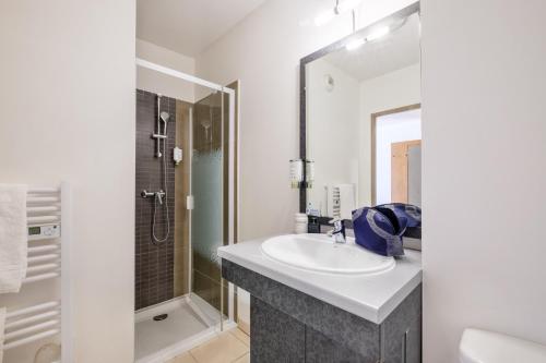 La salle de bains est pourvue d'un lavabo et d'une douche. dans l'établissement Zenitude Hôtel-Résidences Le Maestria, à Antibes