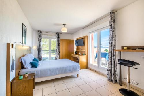 1 dormitorio con cama y ventana grande en Zenitude Hôtel-Résidences Le Maestria, en Antibes