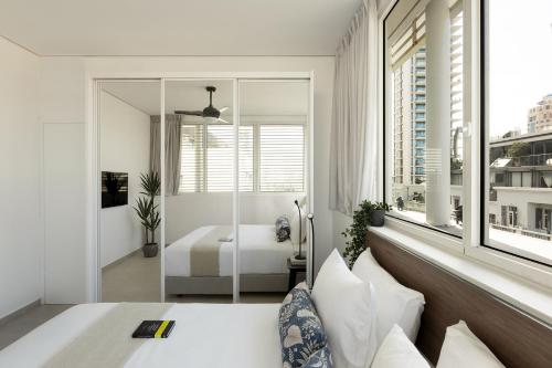 a bedroom with a bed and a large window at Mr. Rothschild by TLV2GO in Tel Aviv
