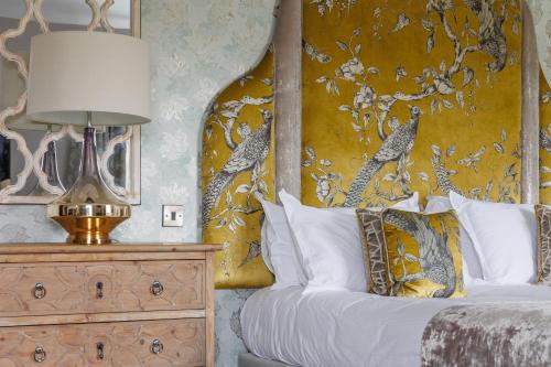 a bedroom with a bed with a yellow wall at Peak Edge Hotel in Chesterfield