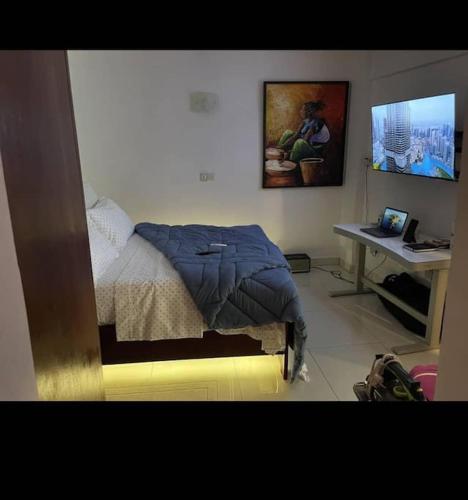 um quarto com uma cama e uma secretária com um computador em Sterling House em Douala
