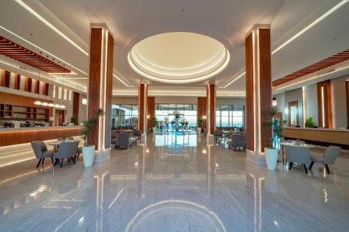 - un hall d'un hôtel avec des tables et des chaises dans l'établissement Pickalbatros Vita Resort - Portofino Marsa Alam, à Abu Dabab