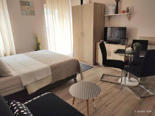 a bedroom with a bed and a table and a television at Apartment Fiume in Rijeka