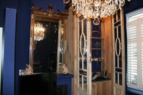 Habitación con espejo y lámpara de araña. en Sint Andries Suites, en Amberes