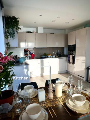 a kitchen with a table with plates and glasses on it at Wembley stadium apartment in London