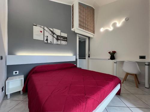 1 dormitorio con cama roja y escritorio en Unplug b&b, en Quartu SantʼElena