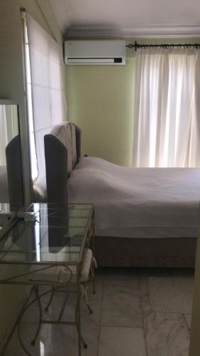 a bedroom with a bed and a table and a window at Villa Alsancak Girne in Karavas
