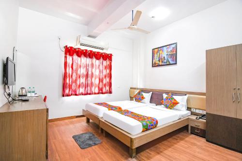 a bedroom with a bed and a red window at FabHotel SS Residency in kolkata