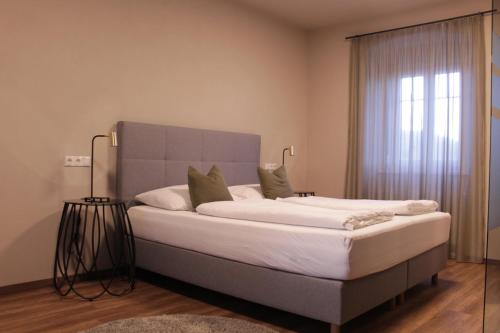 um quarto com uma cama grande e uma janela em Trautes Quartier em Bad Gleichenberg