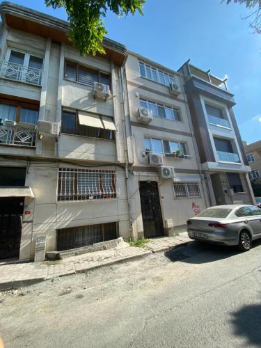 un bâtiment avec une voiture garée devant lui dans l'établissement Bakırköy Selvi Apartmanı, à Istanbul