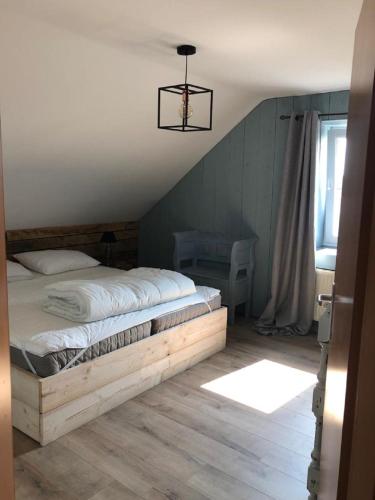 a bedroom with a bed with a wooden frame at Les Hirondelles de Durbuy in Durbuy