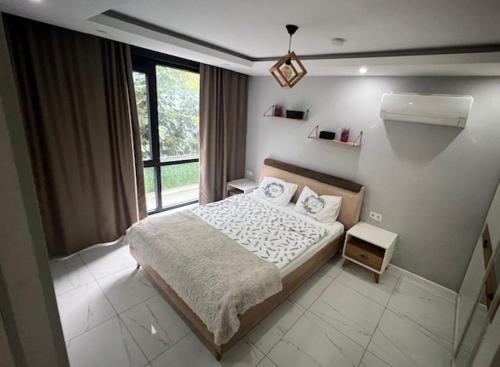 1 dormitorio con cama y ventana grande en City 2, en Alanya