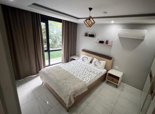 Un dormitorio con una cama y una ventana grande. en City 2, en Alanya