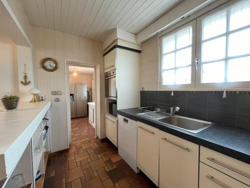 uma cozinha com um lavatório e uma bancada em Maison le Vent du Large em Sibiril