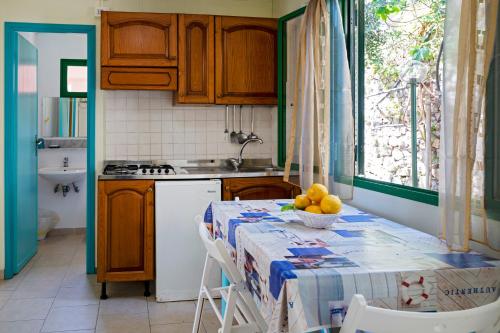 eine Küche mit einem Tisch und einer Obstschale darauf in der Unterkunft Camping Villaggio Nettuno in Nerano