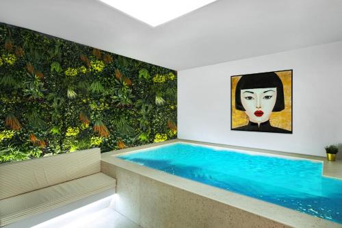 una piscina en una habitación con una pintura en la pared en CITYLUXE Suites & Rooms en Atenas