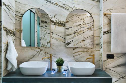 a bathroom with two sinks and two mirrors at CITYLUXE Suites & Rooms in Athens