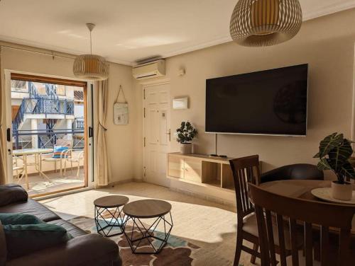ein Wohnzimmer mit Fernseher und Tisch und Stühlen in der Unterkunft Sunny days apartment in Playas de Vera