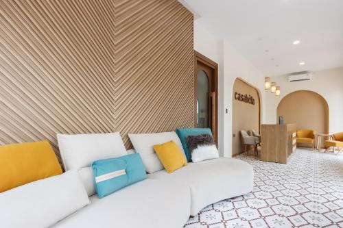 a living room with a white couch with colorful pillows at Casabella Homestay Batam in Nagoya