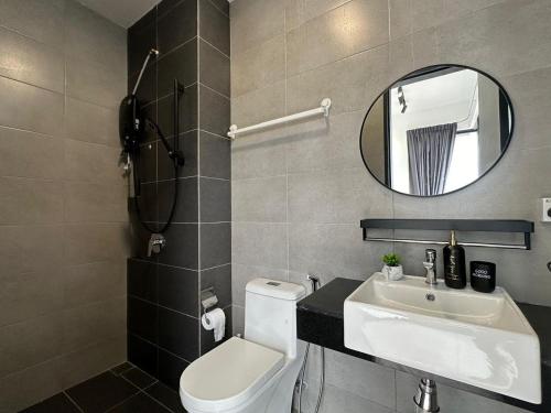 La salle de bains est pourvue de toilettes, d'un lavabo et d'un miroir. dans l'établissement Modern Urban Suites@Georgetown PenangBridgeSeaview, à George Town