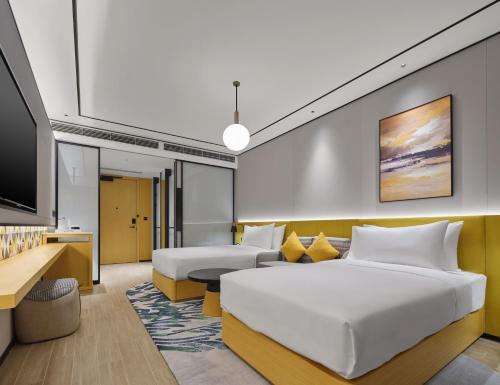 a hotel room with two beds and a flat screen tv at Hilton Garden Inn Kunming Dianchi in Kunming