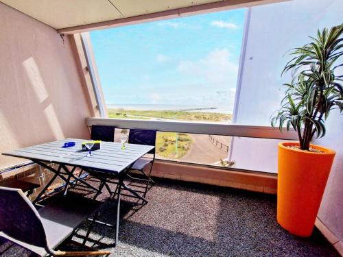 une table et des chaises dans une pièce avec une fenêtre dans l'établissement SUPERBE VUE SUR MER ARC EN CIEL, à Saint-Jean-de-Monts