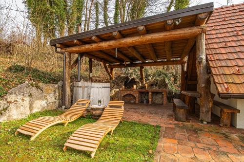 un grupo de sillas sentadas bajo un pabellón de madera en Vineyard Cottage Rataj 2 Wellness - Happy Rentals, en Novo Mesto