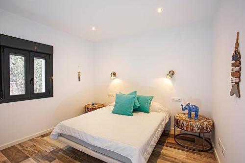 een slaapkamer met een bed met groene kussens en een raam bij Casa Scorpio in Jávea