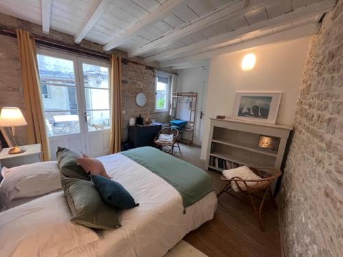 1 dormitorio con 1 cama grande y chimenea en La Bonne Brise, en Grandcamp-Maisy