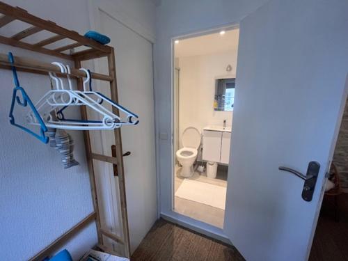 Habitación con baño con aseo y puerta. en La Bonne Brise, en Grandcamp-Maisy