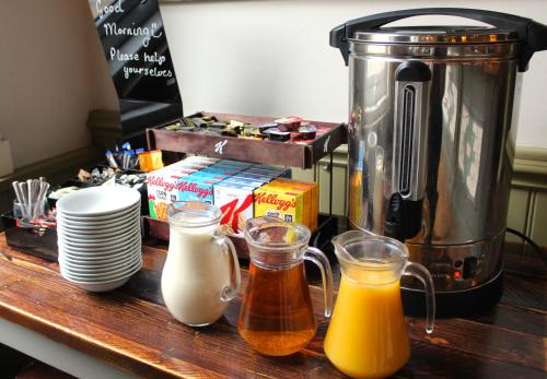 a kitchen counter with a coffee maker and some orange juice at Black Lion Hotel Manchester in Manchester