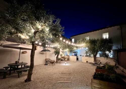 een binnenplaats met een boom met lichten erop bij Villa Maya - 3 Groussan - Avignon - CLIM - TERRASSE in Avignon