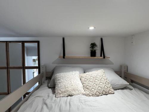 een slaapkamer met een wit bed met kussens erop bij Villa Maya - 3 Groussan - Avignon - CLIM - TERRASSE in Avignon