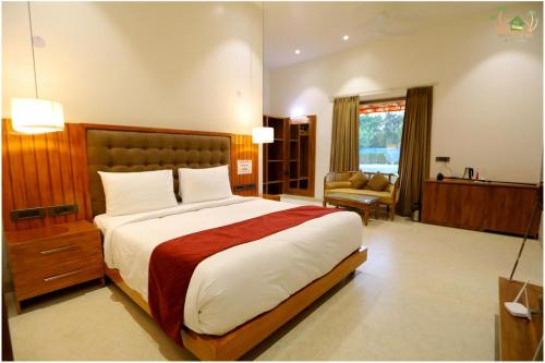 a bedroom with a large bed and a living room at Sahib Farms and Resorts in Delhi