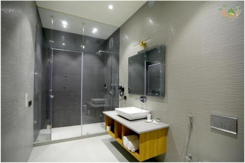 a bathroom with a sink and a shower at Sahib Farms and Resorts in Delhi