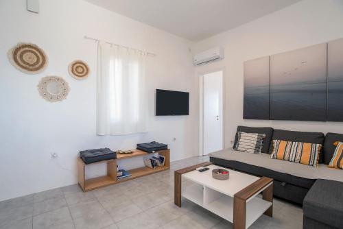 a living room with a couch and a table at Punda Beach Seaside Retreat in Logaras