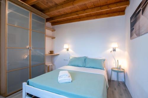 a small bedroom with a bed and a glass door at Punda Beach Seaside Retreat in Logaras