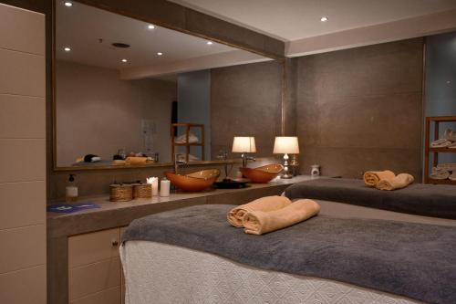 a bathroom with two beds and a large mirror at Restia in Almiros Beach
