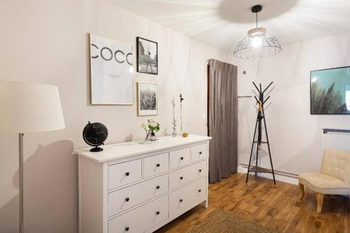 a white dresser in a room with a lamp at Appartement 75006 paris ! in Paris