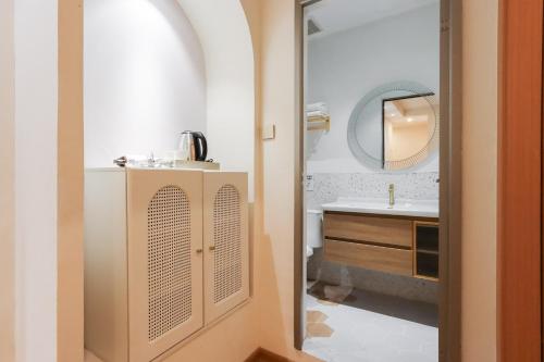 een badkamer met een wastafel en een spiegel bij Casabella Homestay in Nagoya