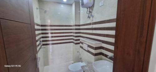 a bathroom with two sinks and a toilet in it at Happy Living in Noida