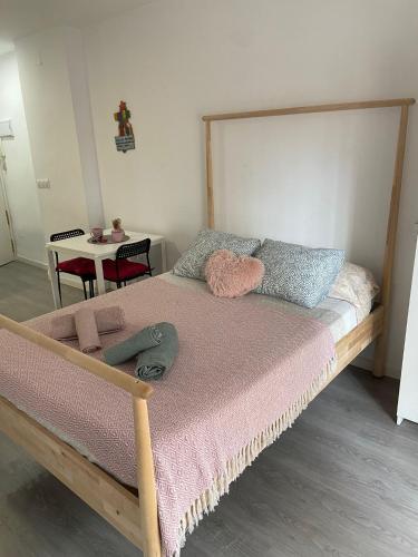- une chambre avec un grand lit et une couverture rose dans l'établissement joan miro, à Torremolinos