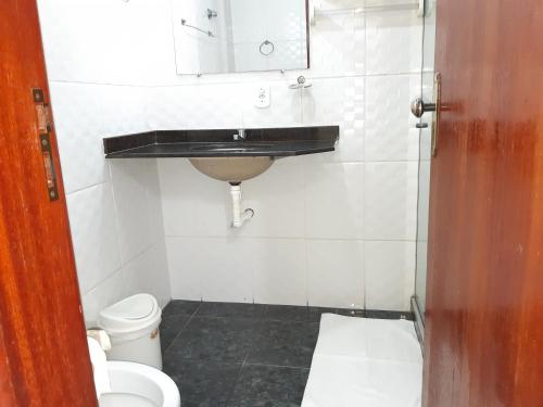 a bathroom with a sink and a toilet at Pousada Aquários in Cabo Frio
